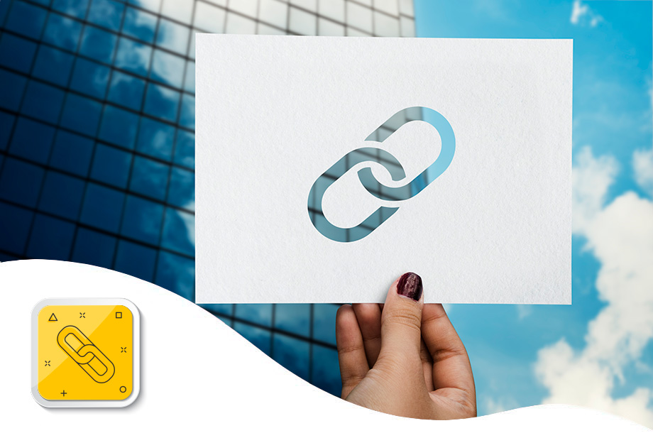 mão feminina segurando folha de papel com desenho do símbolo universal do hiperlink